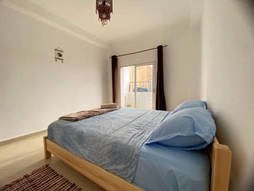ein Schlafzimmer mit einem Bett in einem Zimmer mit einem Fenster in der Unterkunft Spacious Cozy Appartment Akid Lotfi ORAN in Oran
