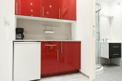 - une cuisine avec des placards rouges et un évier dans l'établissement Nice Renting - GALLO - New Modern Loft Old Town Massena, à Nice