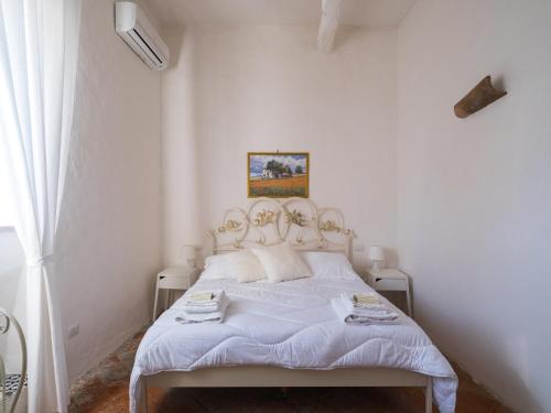 a white bedroom with a bed with white sheets at Ponteronico Resort in Sessa Aurunca