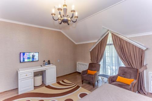 1 Schlafzimmer mit einem Bett, 2 Stühlen und einem Schreibtisch in der Unterkunft Aynur Resort in Quba