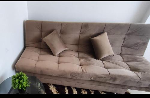 a brown couch in a living room with pillows at Apartamento en el Centro in Santa Cruz de la Sierra