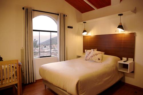 a bedroom with a bed and a large window at Finca Ramos Mejia in Coporaque