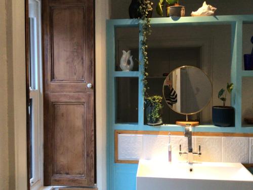 une salle de bain avec un lavabo et un miroir dans l'établissement Mansefield Rooms, à Lockerbie