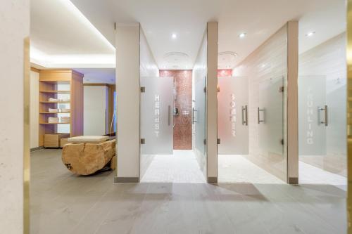 un corridoio con pareti bianche e una camera con divano di Sporthotel Neustift a Neustift im Stubaital