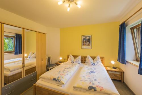 a bedroom with a large bed with yellow walls at Haus Sandra in Kitzbühel