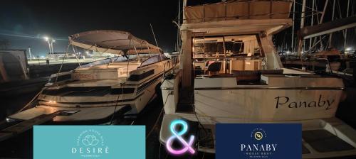 twee boten zijn aangemeerd in een haven 's nachts bij Desirè charming house boat in Palermo