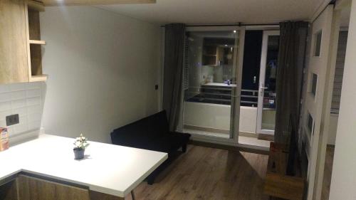 uma cozinha com uma mesa branca e um quarto com vista em Apartamento La Florida Mirador Oriente em Santiago