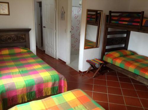 a room with two bunk beds and a mirror at Villa Liliana Lodge Mesa de los Santos in Los Santos