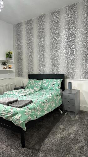 um quarto com uma cama com um edredão verde em Ur Place 204 em Manchester