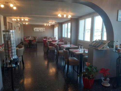 a dining room with tables and chairs and windows at Chez Nous in Fitou