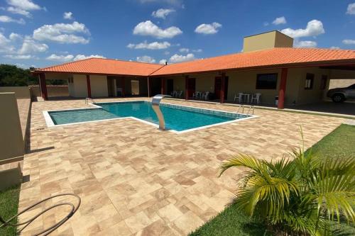 a swimming pool in front of a house at Chácara Mahalo’s in Sorocaba