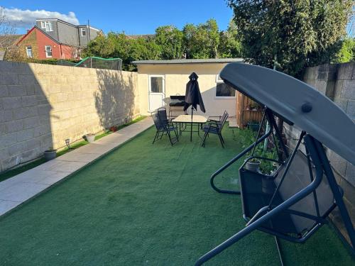 a backyard with a green lawn with a table and chairs at ELSARO guest house in Slough