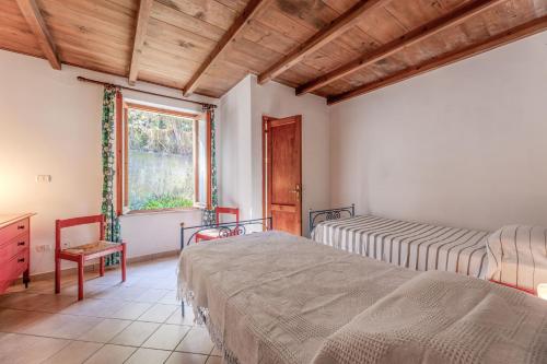 a bedroom with two beds and a window at Villetta Bagnaia - Goelba in Bagnaia