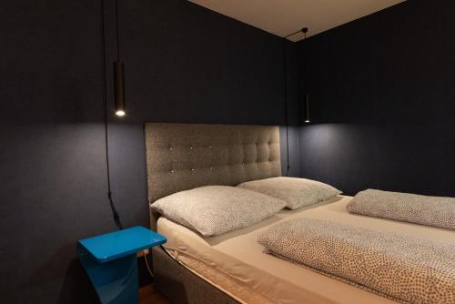 ルストにあるNi Apartmentsの青いテーブル付きの客室で、ツインベッド2台が備わります。