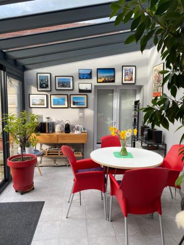 a living room with a table and red chairs at La Maison Angèle in Caisnes