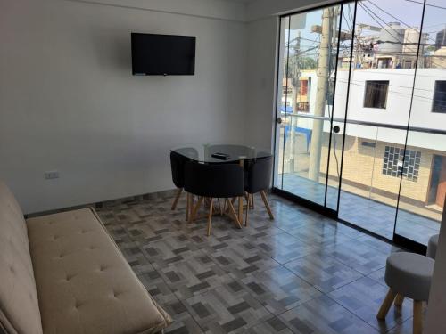 een woonkamer met een tafel en stoelen en een televisie bij MIEL DE LUNA in Cerro Azul