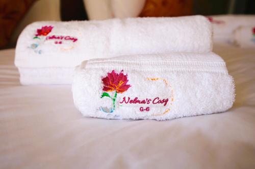 um par de toalhas sentadas em cima de uma cama em Nelma's Cosy em Nuwara Eliya