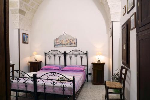 1 dormitorio con cama negra con sábanas rosas en B&B Casina Le Rene, en Poggiardo
