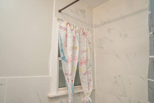 een douchegordijn in een badkamer met een raam bij Cozy apartment in Irvington. in Irvington