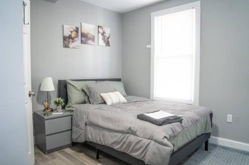 een slaapkamer met een bed en een raam bij Cozy apartment in Irvington. in Irvington