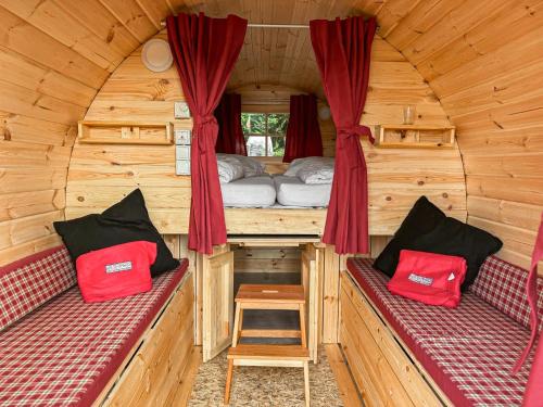 ein Zimmer mit zwei Bänken in einer Holzhütte in der Unterkunft Das Wiesenhaus Wohnen im Schlaffass in Köln