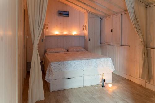 una camera con un letto bianco e pavimenti in legno di Camping Arutoli a Porto Vecchio