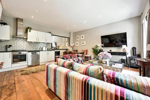 Il comprend un grand salon avec des canapés et une cuisine. dans l'établissement Magnificent 2 Bed Hyde Park Mews House, à Londres