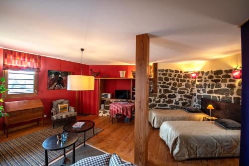 a bedroom with red walls and a room with two beds at Chambre d'Hôtes et gites du Tapissier in Polignac