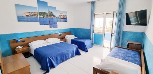 a hotel room with two beds and a window at Hotel Blu Eden in Praia a Mare