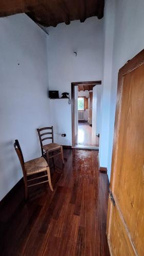 ein Wohnzimmer mit einem Stuhl und Holzboden in der Unterkunft Appartamento con vista su Firenze in Lastra a Signa
