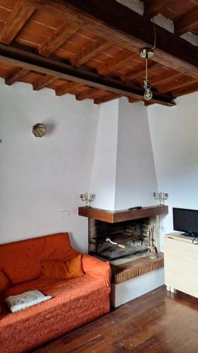ein Wohnzimmer mit einem roten Sofa und einem Kamin in der Unterkunft Appartamento con vista su Firenze in Lastra a Signa