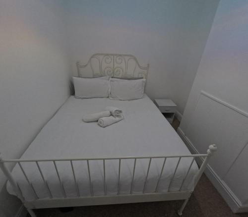 a white bed with a white headboard and pillows at King Size Bed Room with Private Gym Access in Portsmouth