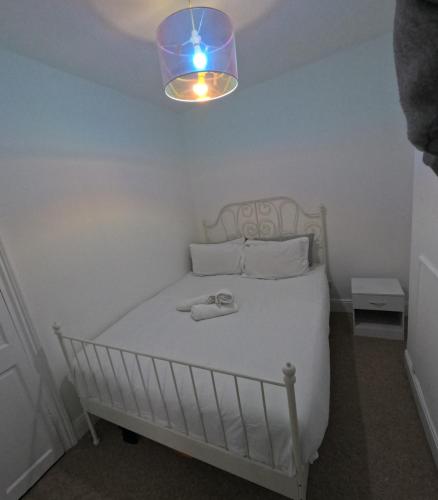 a white bed in a room with a light at King Size Bed Room with Private Gym Access in Portsmouth