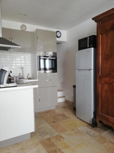 uma cozinha com um frigorífico branco e um micro-ondas em maison de village em Vias