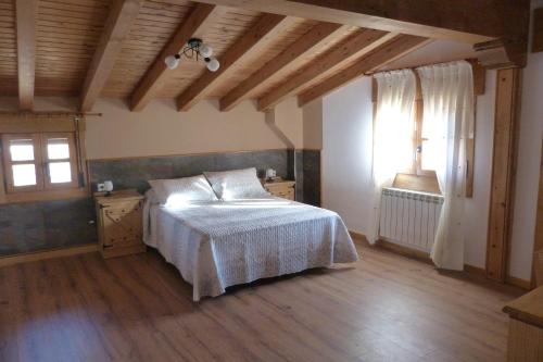 een slaapkamer met een bed in een kamer met houten vloeren bij El Farolillo de Piedra in Montejo de Tiermes