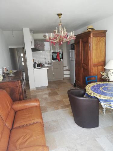 uma cozinha e uma sala de estar com um sofá e uma mesa em maison de village em Vias