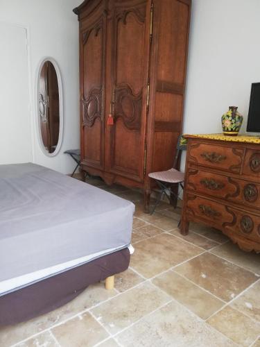 um quarto com uma cama e uma cómoda em madeira em maison de village em Vias