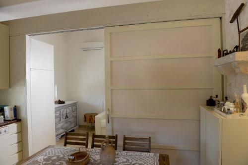 a kitchen with a table and a refrigerator at Trulli Lisanna - Exclusive Trulli With Private Pool in Antonelli