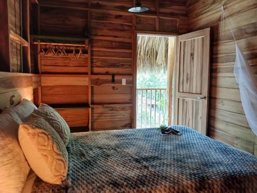 a bedroom with a bed in a log cabin at Casa Sol Y Sombra in Santa Marta