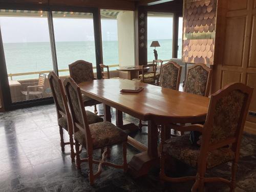 une salle à manger avec une table et des chaises et l'océan dans l'établissement La croisière, à Étretat