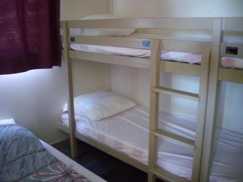 a bunk room with a bed and a bunk bed gmaxwell gmaxwell gmaxwell gmaxwell gmaxwell gmaxwell at Belles vacances aux chalets Casteljaloux in Casteljaloux