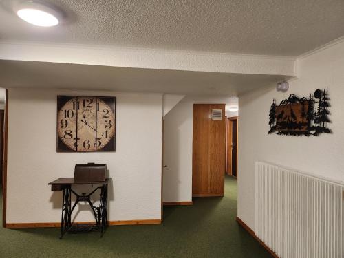a hallway with a clock on the wall and a table at Hôtel Au Vieux Moulin in Lapoutroie