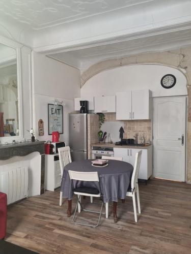 une cuisine et une salle à manger avec une table et des chaises dans l'établissement Studio le RED SOFA, cœur de ville, à La Ciotat