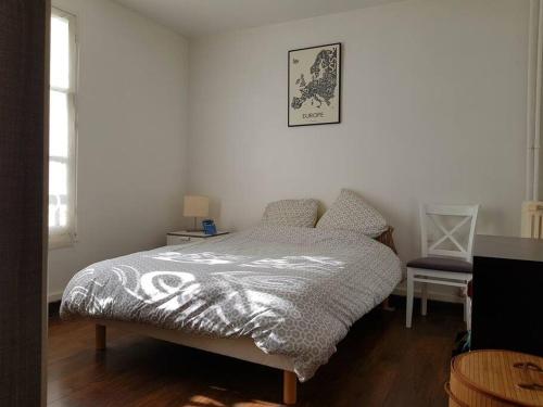 une chambre avec un lit dans une pièce blanche dans l'établissement Bel Appartement Colombes Centre, à Colombes