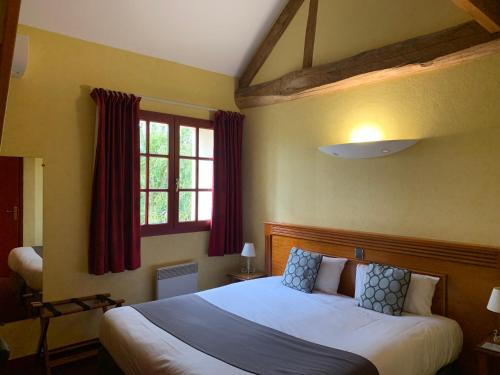 une chambre avec un grand lit et une fenêtre dans l'établissement Logis Hôtel Restaurant Le Moulin de la Coudre, à Venoy