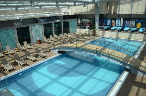 una grande piscina in un edificio con sedie di Luxury Hotel Concept Apartment a Istanbul
