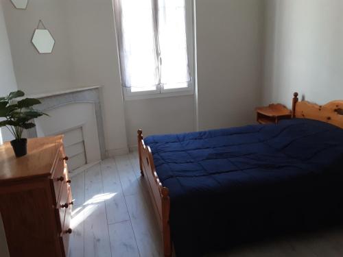 une chambre avec un lit bleu et une fenêtre dans l'établissement maison les lilas, à Menton