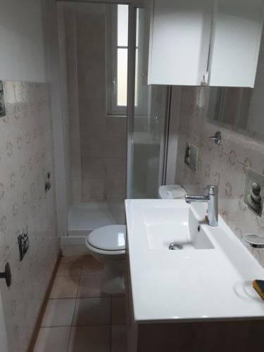 une salle de bain avec un lavabo blanc et des toilettes dans l'établissement maison les lilas, à Menton