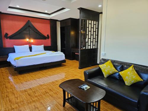um quarto de hotel com uma cama e um sofá em Nanai 2 Residence Patong Phuket em Praia de Patong
