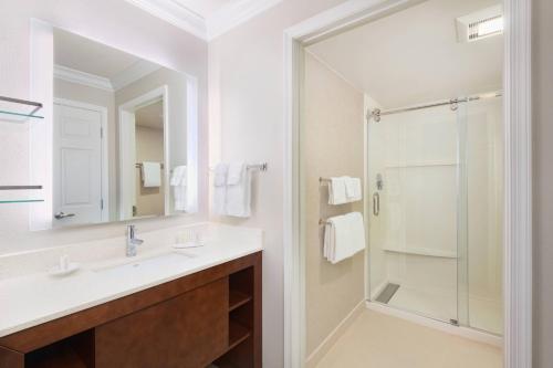 a white bathroom with a sink and a shower at Residence Inn by Marriott State College in State College